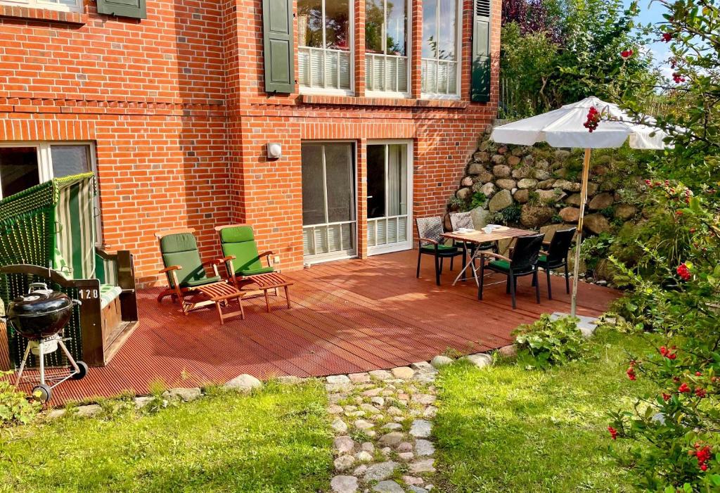 格洛韦Ein-Steinwurf-zum-Ostseestrand-Ferienwohnung-Martha-mit-Terrasse的庭院配有桌椅和遮阳伞。