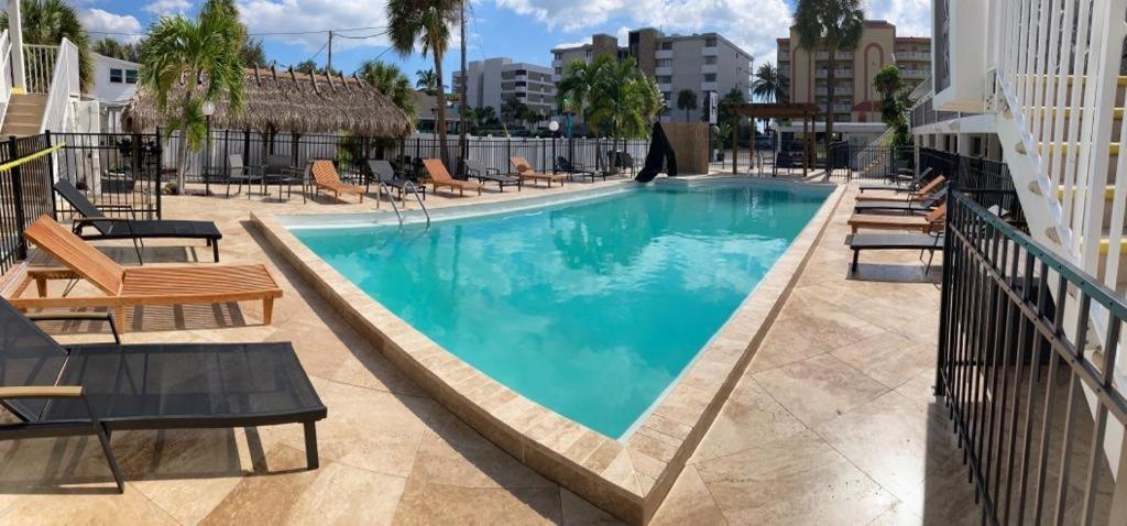 圣徒皮特海滩假日岛度假酒店的一个带躺椅的游泳池和一间酒店