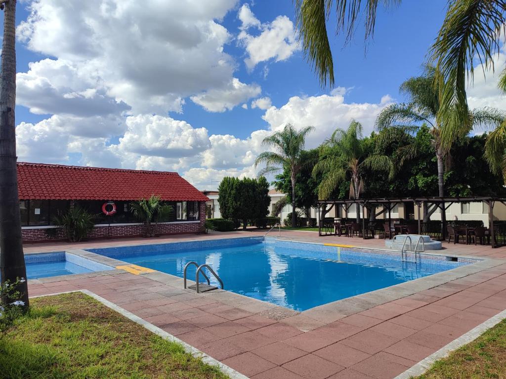 阿瓜斯卡连特斯HOTEL SAN MARCOS的棕榈树度假村内的游泳池