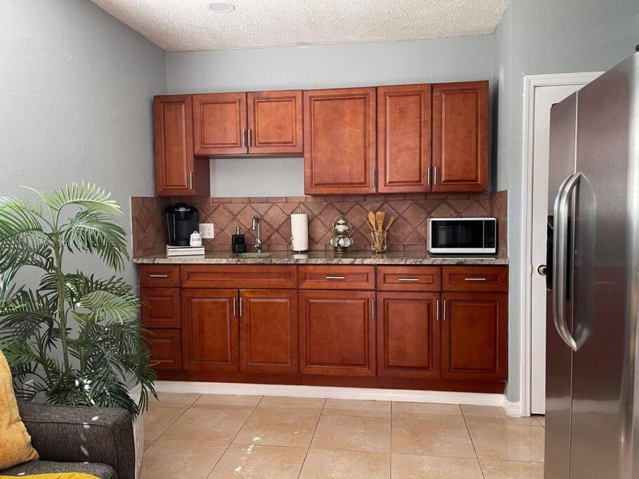 坦帕The Citrus Guesthouse in Tampa的厨房配有木制橱柜和不锈钢冰箱。