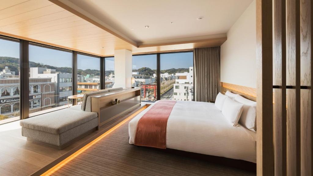 镰仓市Hotel Metropolitan Kamakura的酒店客房设有一张床和一个大窗户