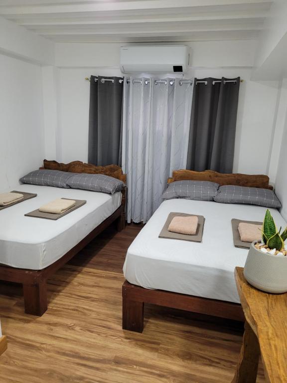 那牙Borj Place的配有2张床的木地板客房