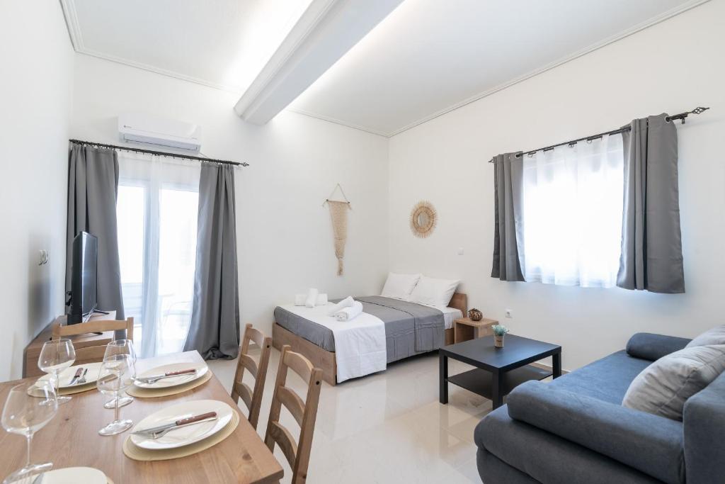 雅典Blue Riviera villas & suites - Alimos 2的客厅配有床和餐桌