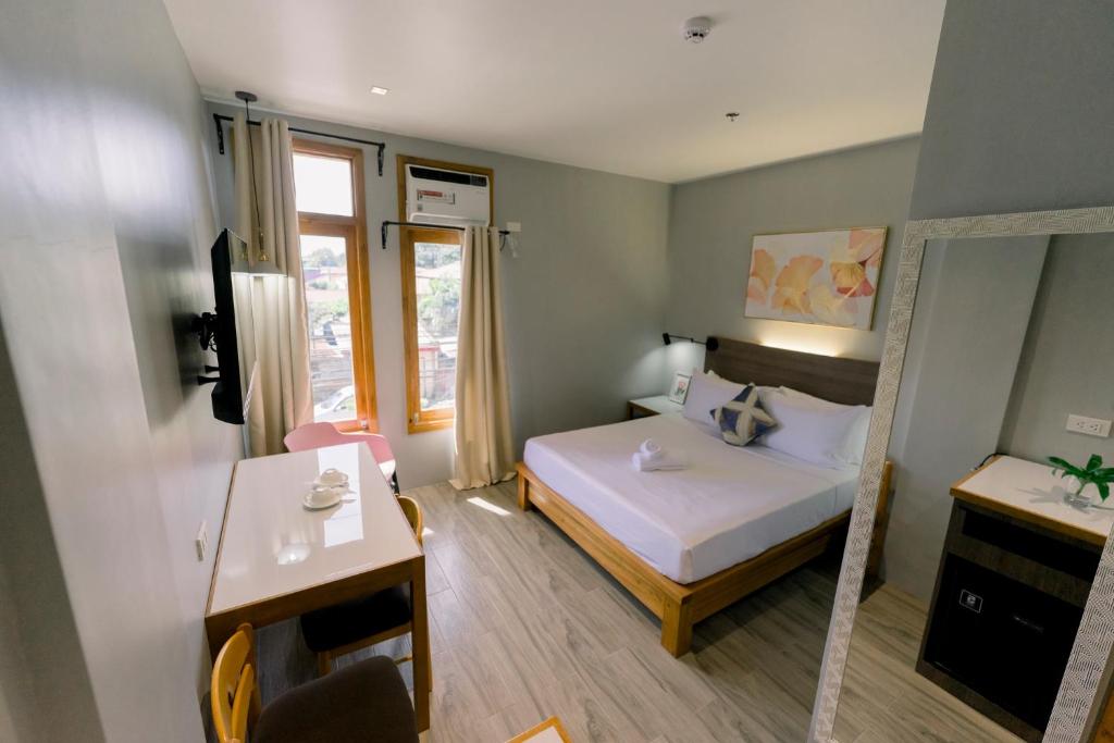 PanaboMadonna Hometel and Suites New Pandan的小房间设有床和镜子