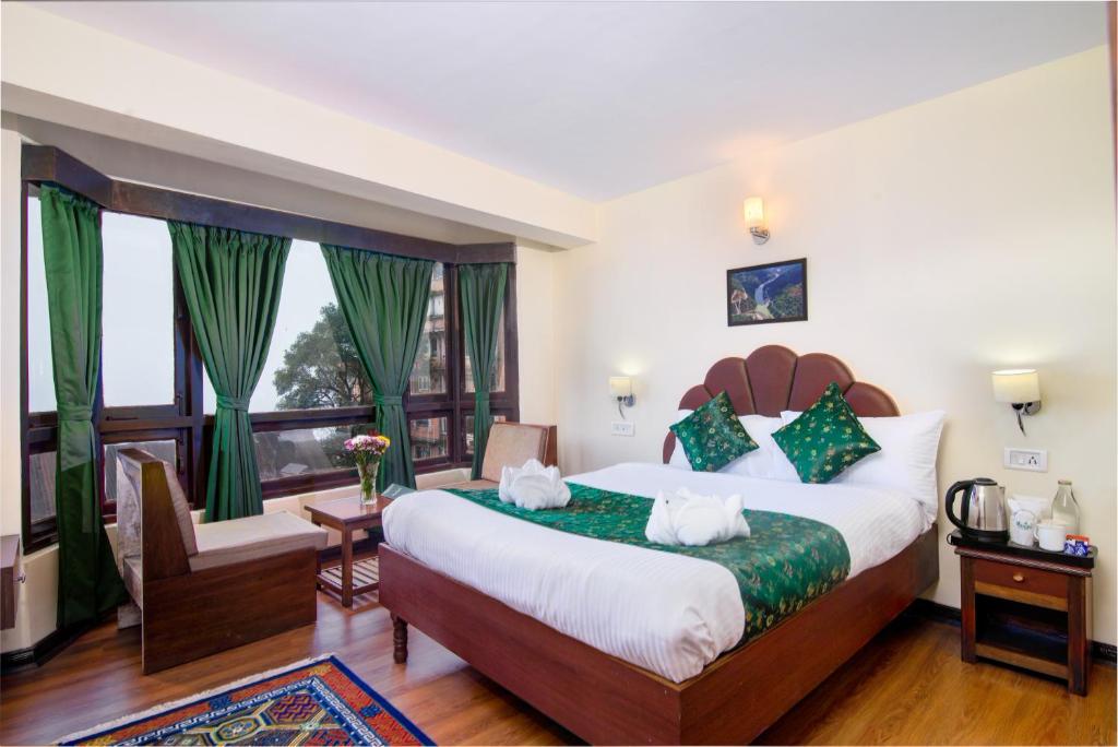 大吉岭Muscatel BhumSang - 200 Mts from Mall Road的一间卧室设有一张大床和一个大窗户