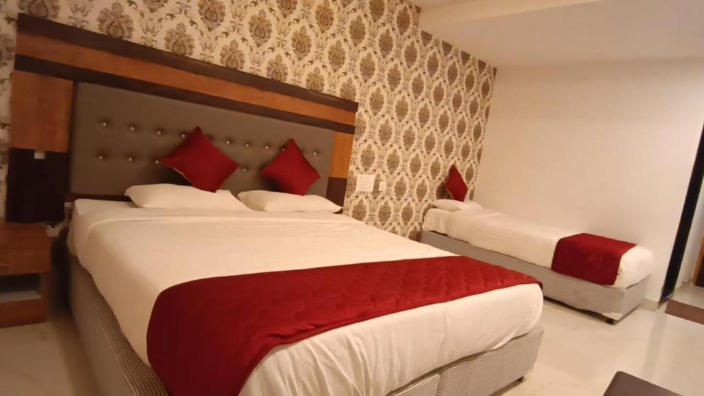 蒂鲁帕蒂Hotel Woodside Prestige的一间卧室配有两张带红色枕头的床