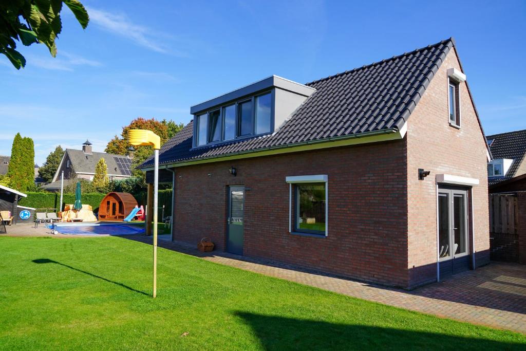 SchijndelPrachtig royaal gastenverblijf的红砖房子,有 ⁇ 帽屋顶