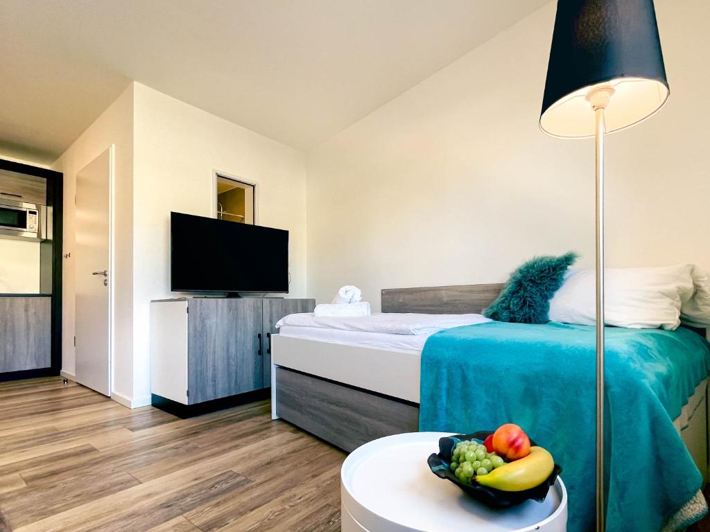 赖恩海姆Stilvolles Apartment mit Parkplatz, barrierefrei的一间卧室配有一张床,桌上放着一碗水果