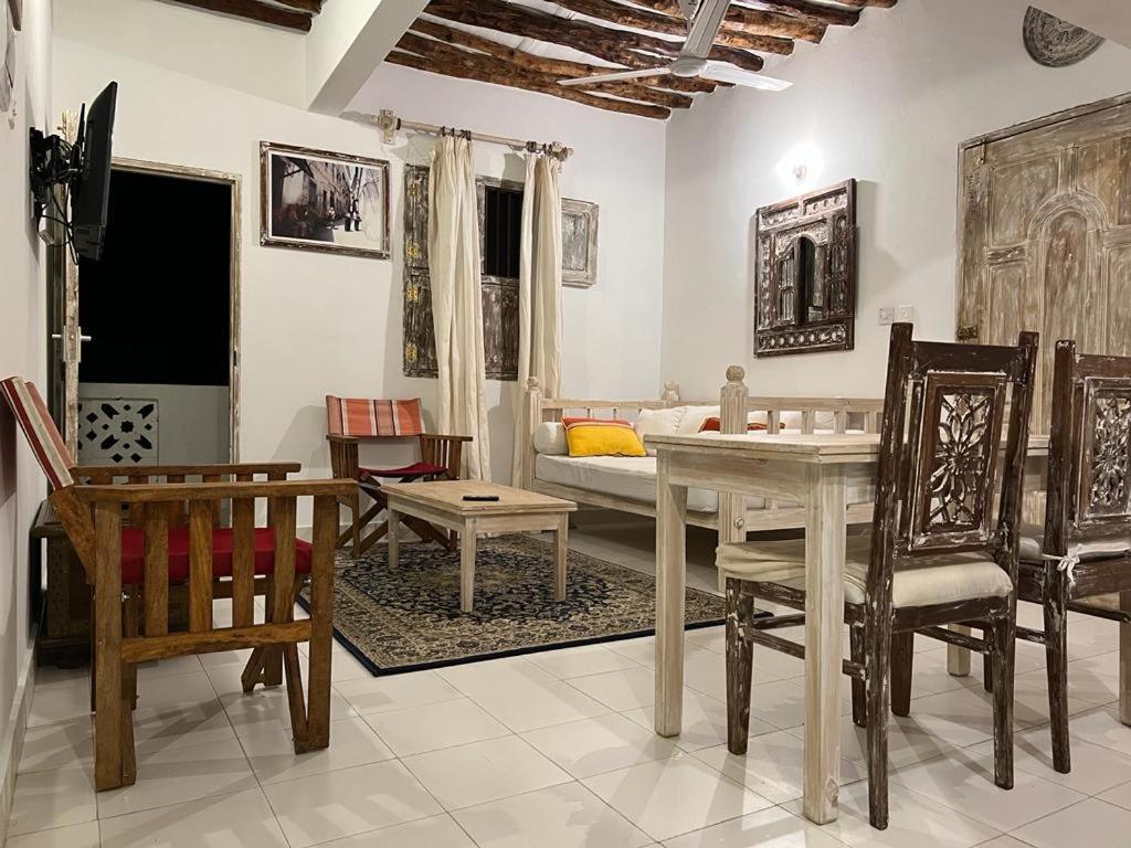 拉穆Beytsalaam Apartments的客厅配有桌椅和沙发