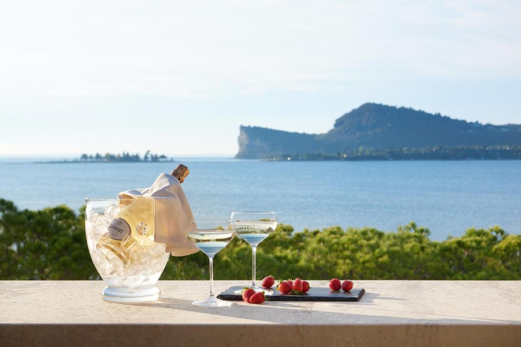 圣费利切德尔贝纳科索尼欧餐厅酒店的一张桌子,上面放着两杯葡萄酒和一盘水果