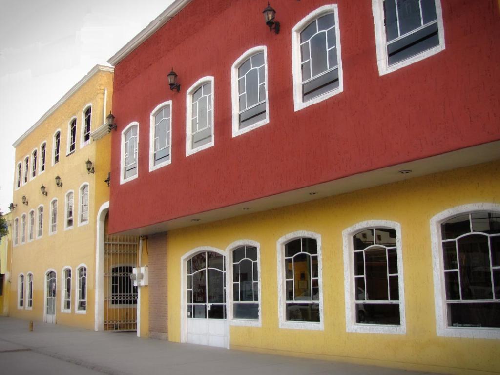 圣路易斯波托西圣路易斯酒店的红色和黄色的建筑,设有白色的窗户