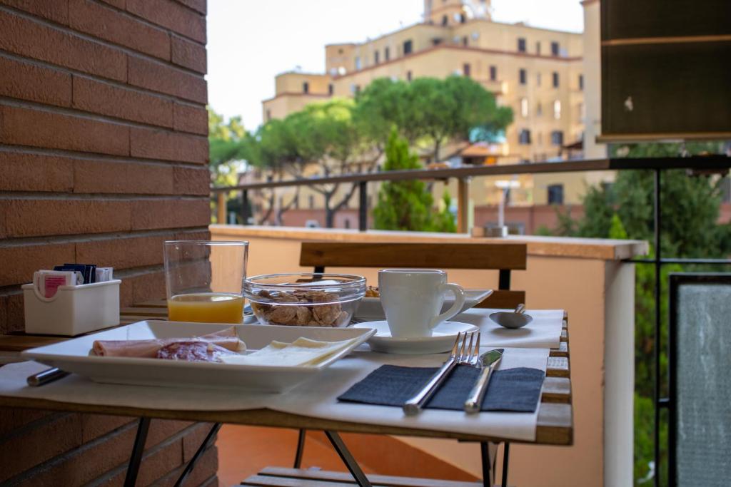 罗马B&B JONIO Roma的阳台上的餐桌上放着一盘食物