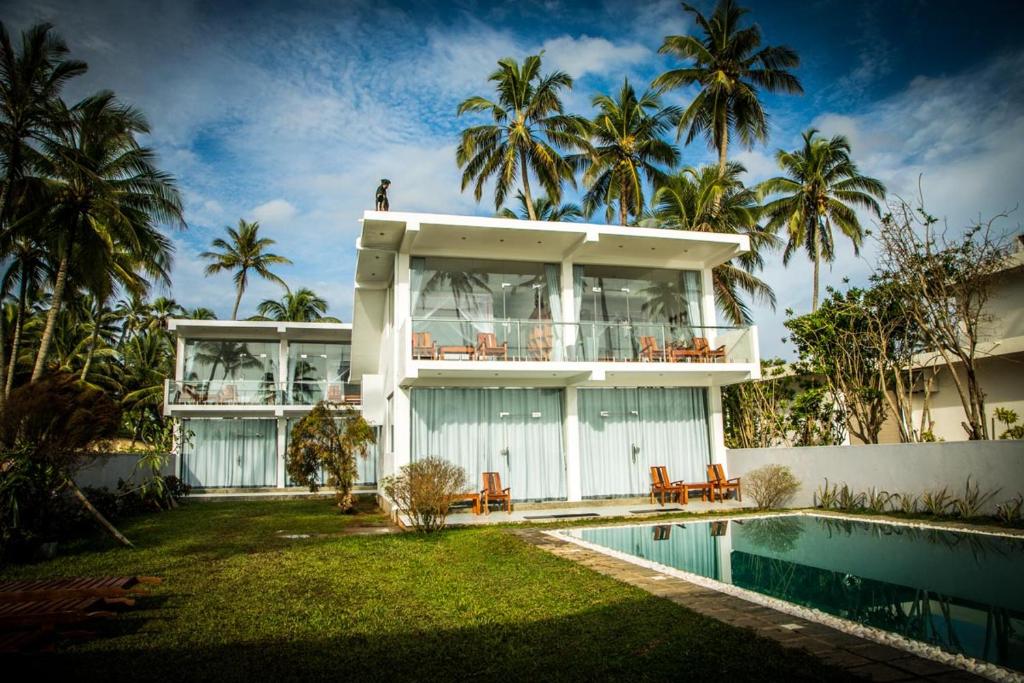 Paiyagala SouthInfinity of Sri Lanka的一座带游泳池和棕榈树的房子