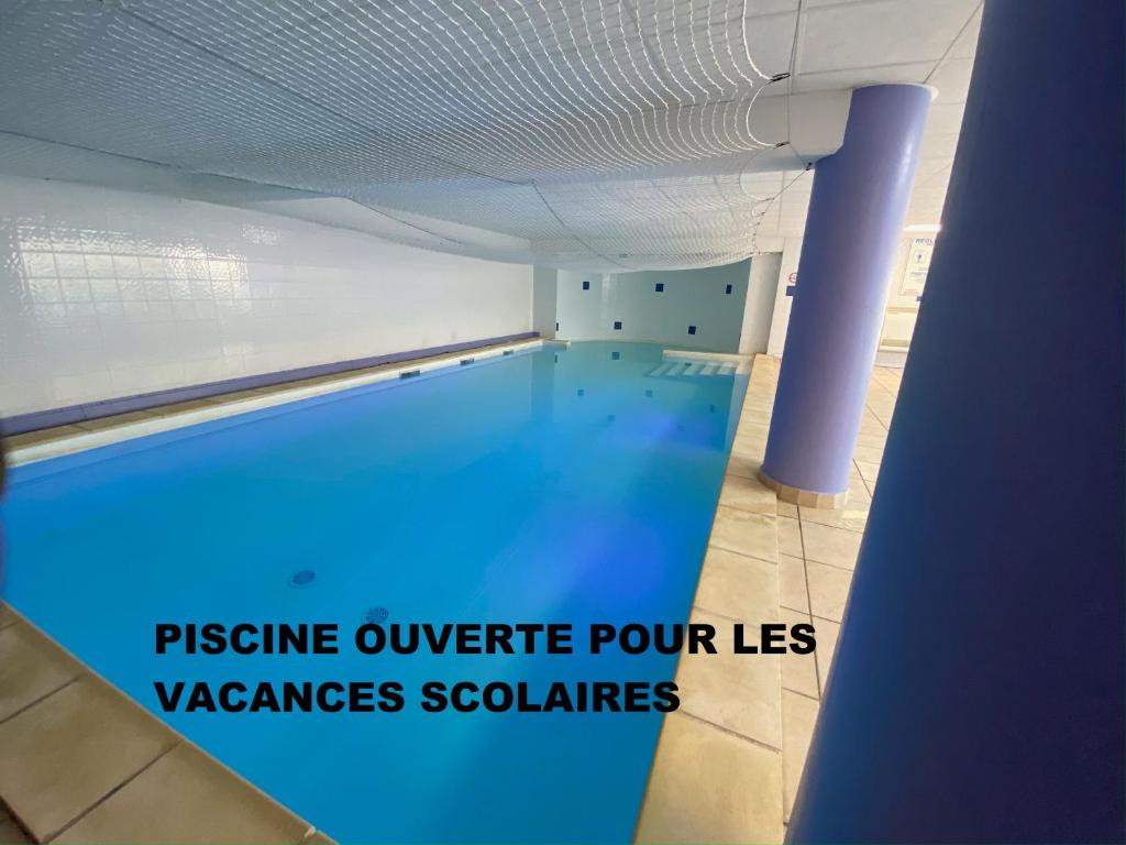 于泽斯奥利威尔尤赛公寓酒店的大楼内的一个蓝色海水游泳池