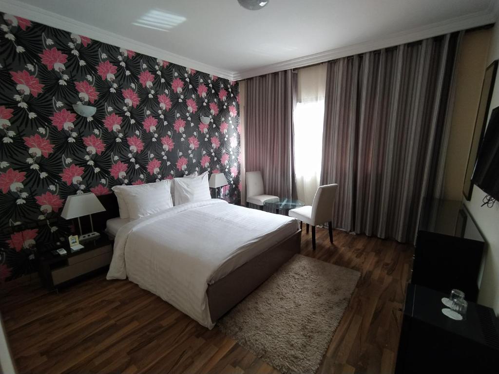 拉巴特海尔南谢尔酒店的一间卧室设有一张床和花卉墙