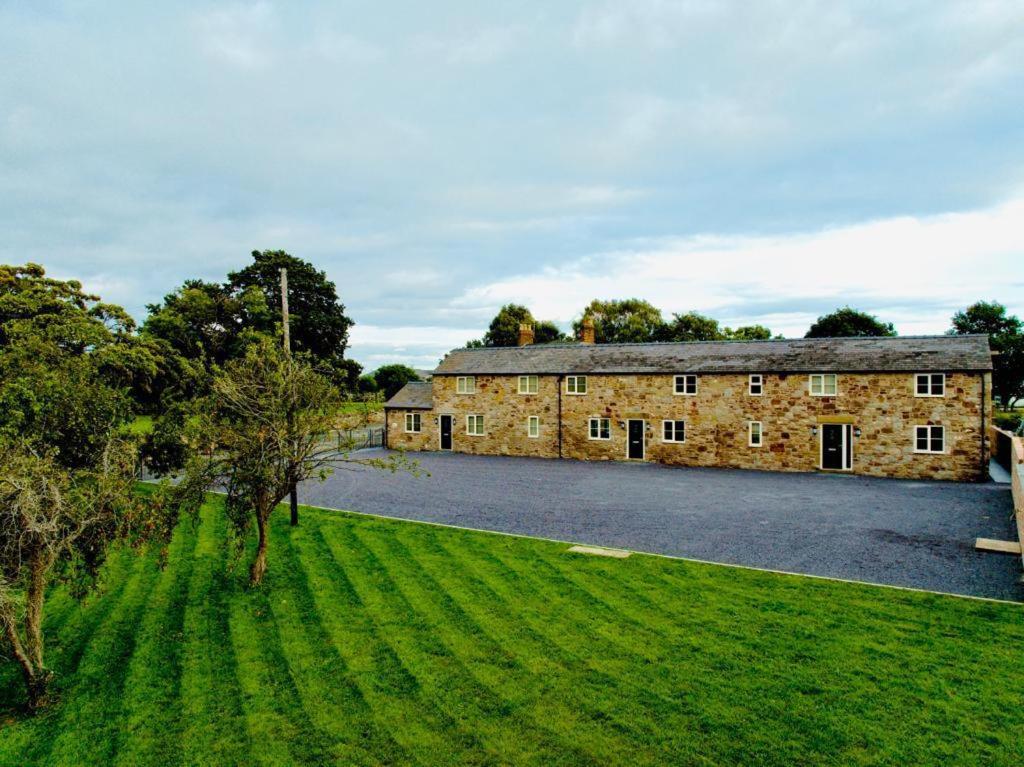 Connahs QuayConnah's Quay Park Farm Barns的一座古老的石头建筑,前面有一片绿地