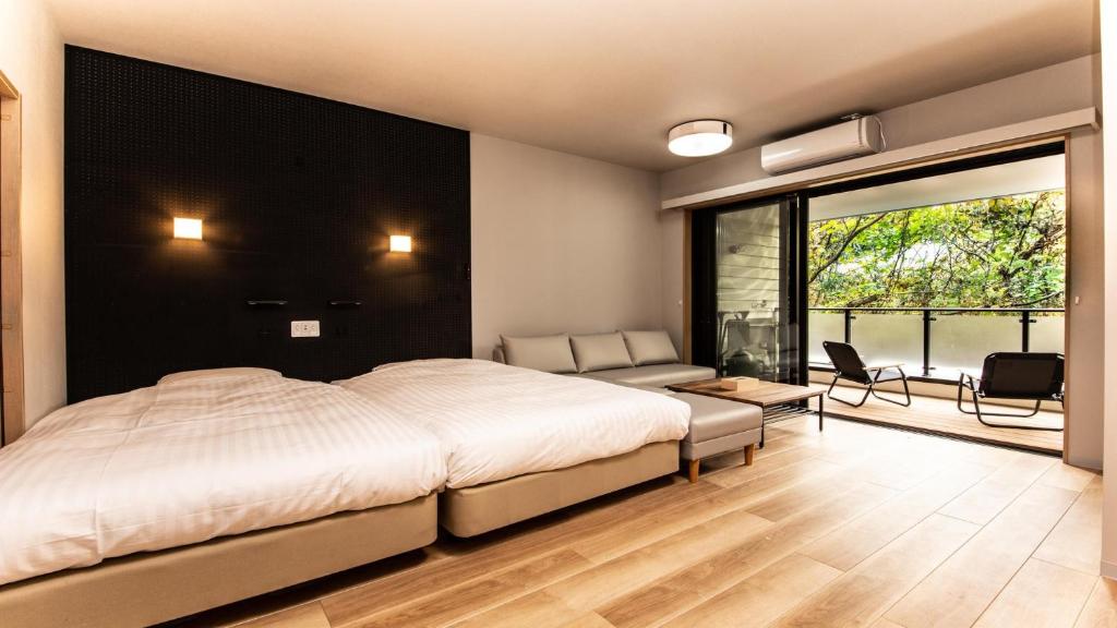日光Rakuten STAY MOTEL Nikko Kinugawa Standard Room的一间带大床的卧室和一间客厅