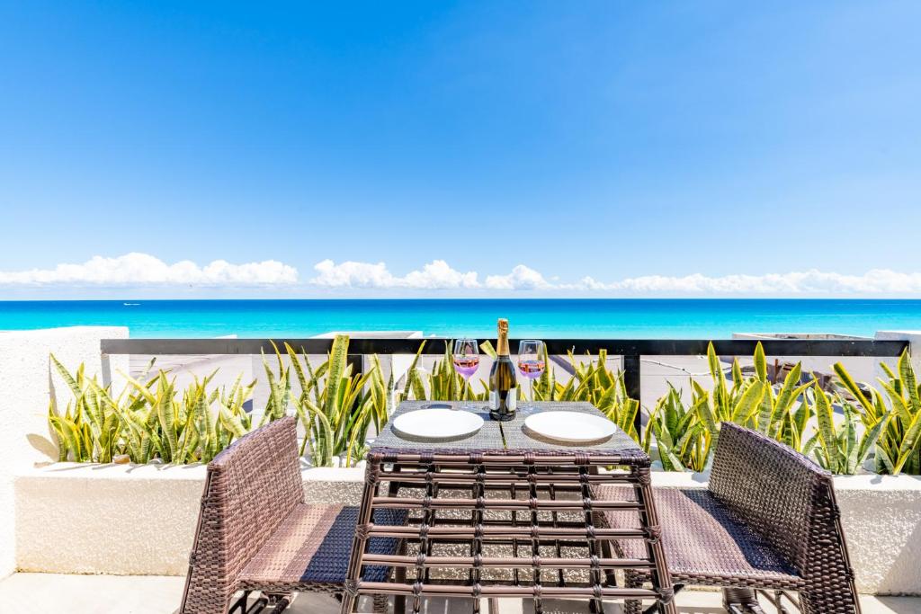 坎昆Cancun Ocean view的一张桌子和椅子,背景是大海