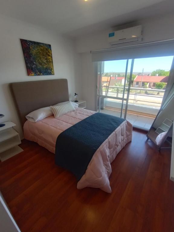 维多利亚Colina Dom的一间卧室设有一张床和一个大窗户