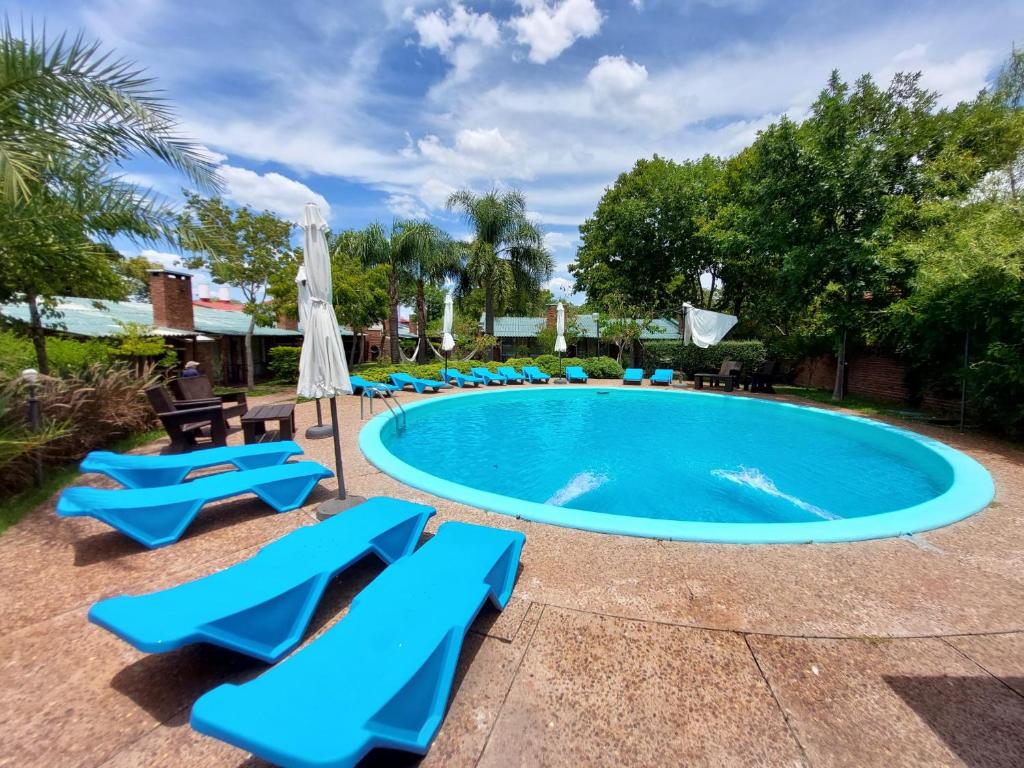 特玛斯德戴曼卡尔达斯戴曼酒店的一个带蓝色椅子和遮阳伞的游泳池