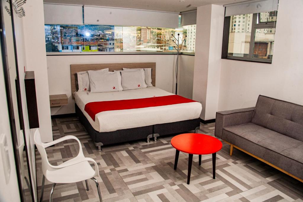 帕斯托Hotel Star Pasto的一间卧室配有一张床、一张沙发和一把椅子