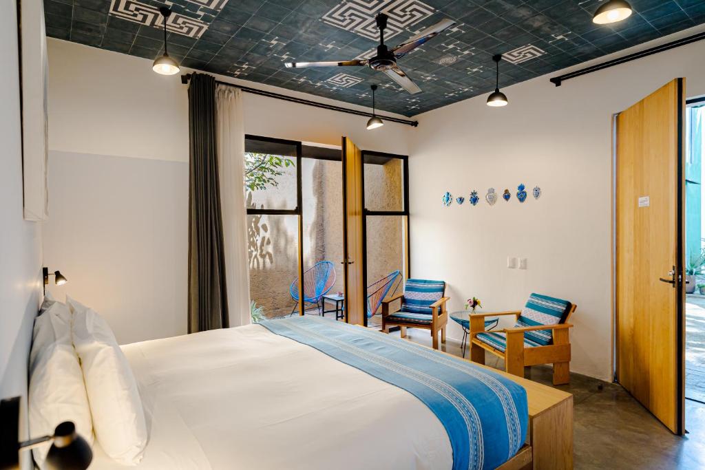 瓦哈卡市Hotel con Corazón的一间卧室配有床、椅子和窗户
