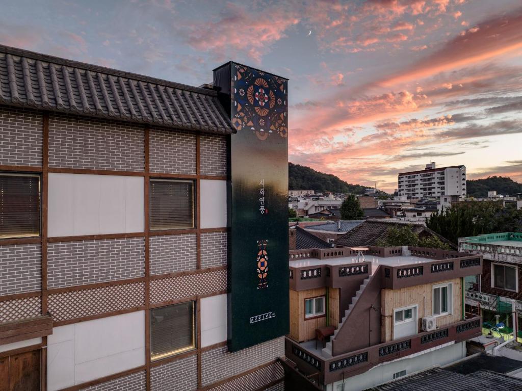 全州市HotelArrive Jeonju Sihwayeonpung的享有建筑美景,背景是日落