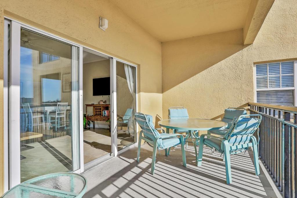 圣徒皮特海滩Palms of Treasure Island 208的阳台的天井配有桌椅