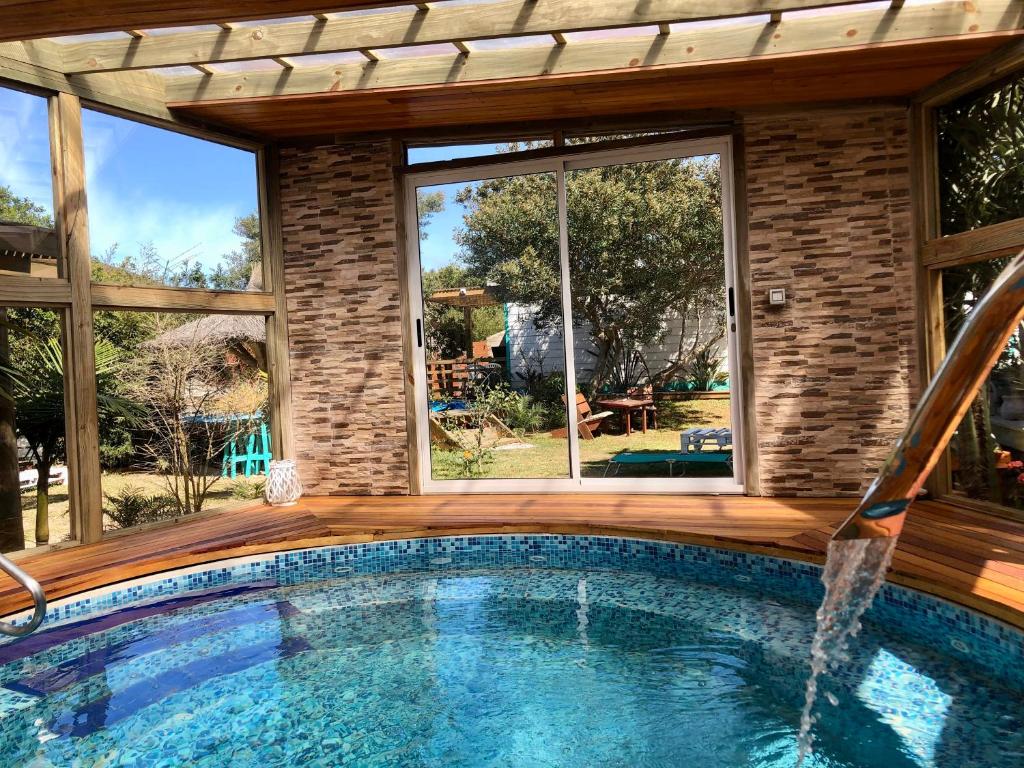 拉帕洛马Posada Agua Marina的一座带大窗户的房屋内的游泳池