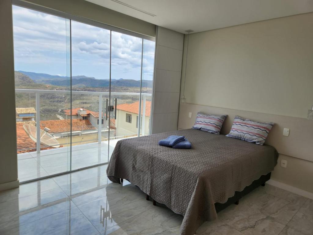 迪亚曼蒂纳Apto inteiro de luxo em Diamantina的一间卧室设有一张床和一个大窗户