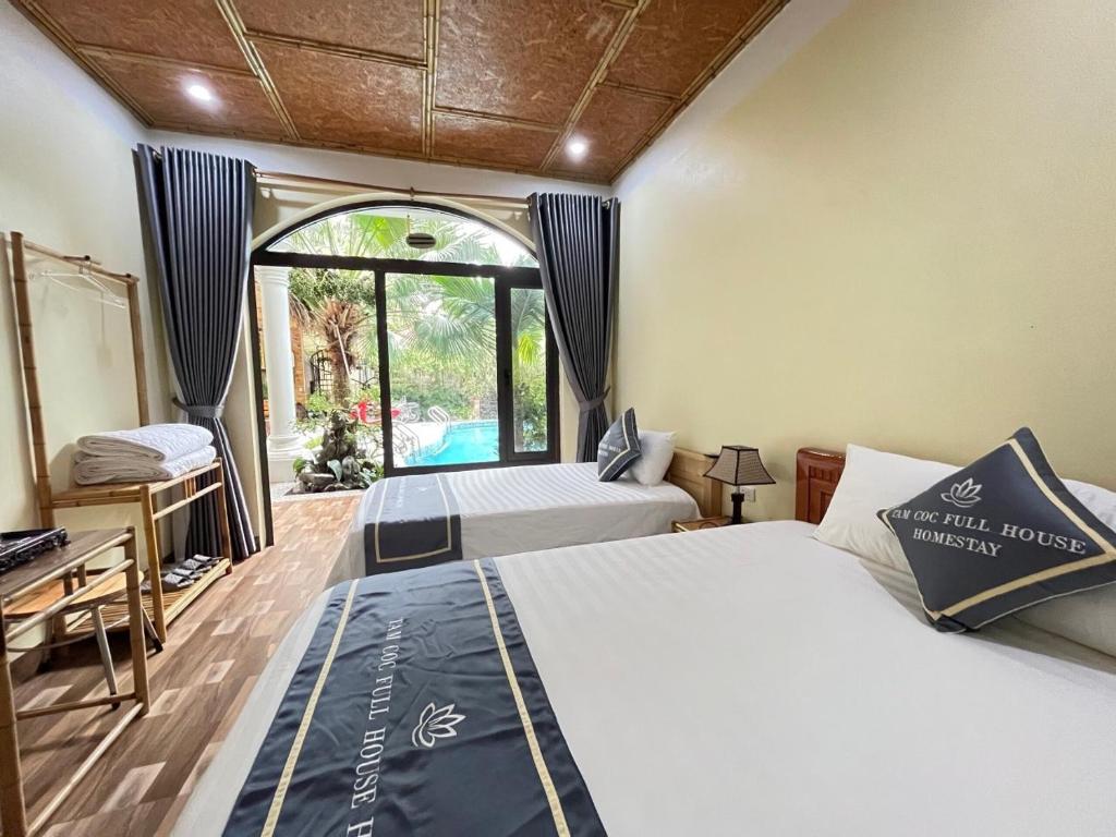 宁平Tam Coc Full House Homestay的一间卧室设有两张床和窗户。