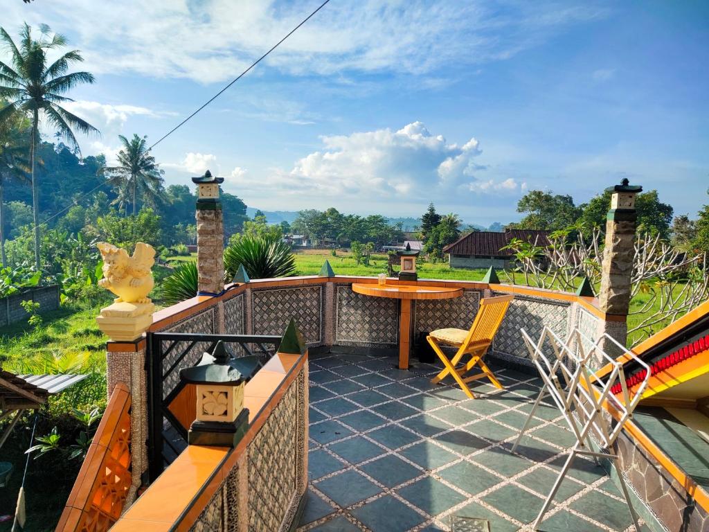 Tirtagangga道尔民宿酒店的阳台的天井配有桌椅