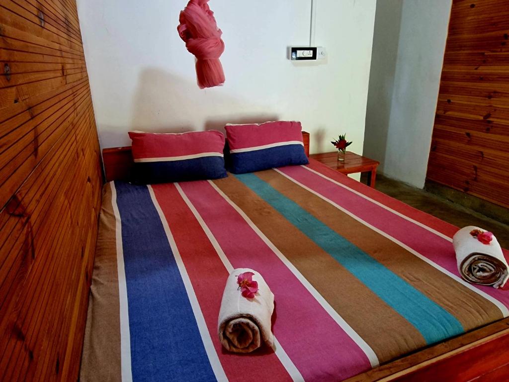 亭可马里Walkers hostel的一间卧室配有带毛巾的床