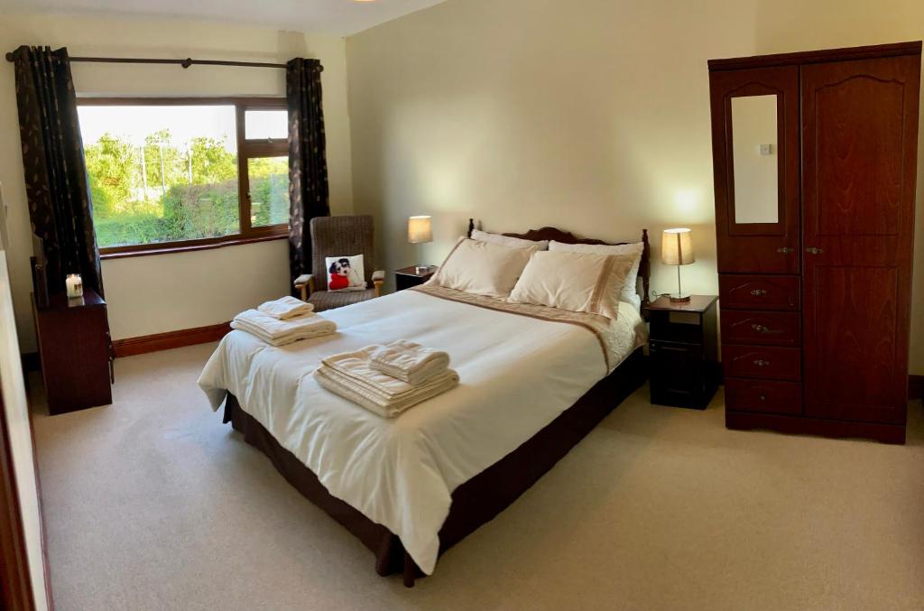 斯莱戈Lily's - 3 Bedroom Country Cottage with Large Garden的一间卧室配有一张大床和毛巾