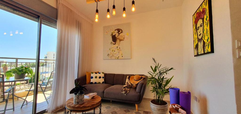 埃拉特מלוני דירות נופש אילת - Melony Apartments Eilat的带沙发的客厅和阳台
