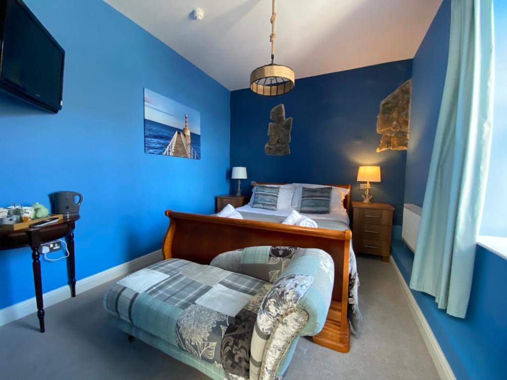 安布尔Harbour Inn的蓝色卧室,配有床和椅子