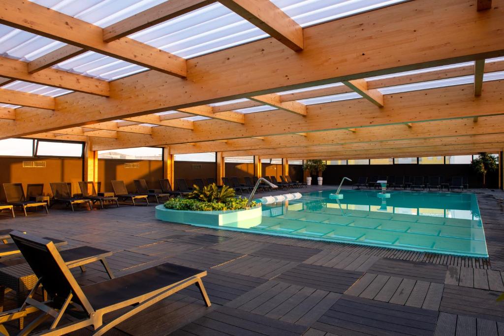 普拉亚达维埃拉Hotel Cristal Vieira Praia & SPA的一个带天窗屋顶的室内游泳池