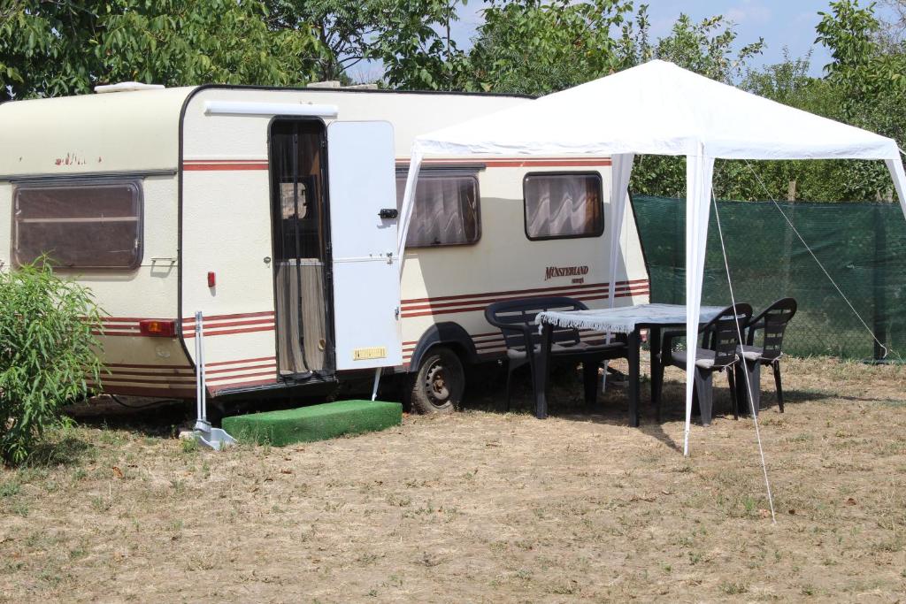 GranicharKemping pod figą的白色大篷车,配有桌子和帐篷