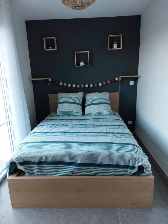 Mont-lʼEvêqueChambre d’hôte Chancelier Guerin的一间卧室配有一张带蓝色床单和蓝色枕头的床。