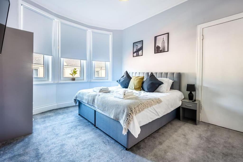 威萧Kali Apartment - Spacious 3 bed apartment in Wishaw的卧室设有蓝色和白色的床和窗户。