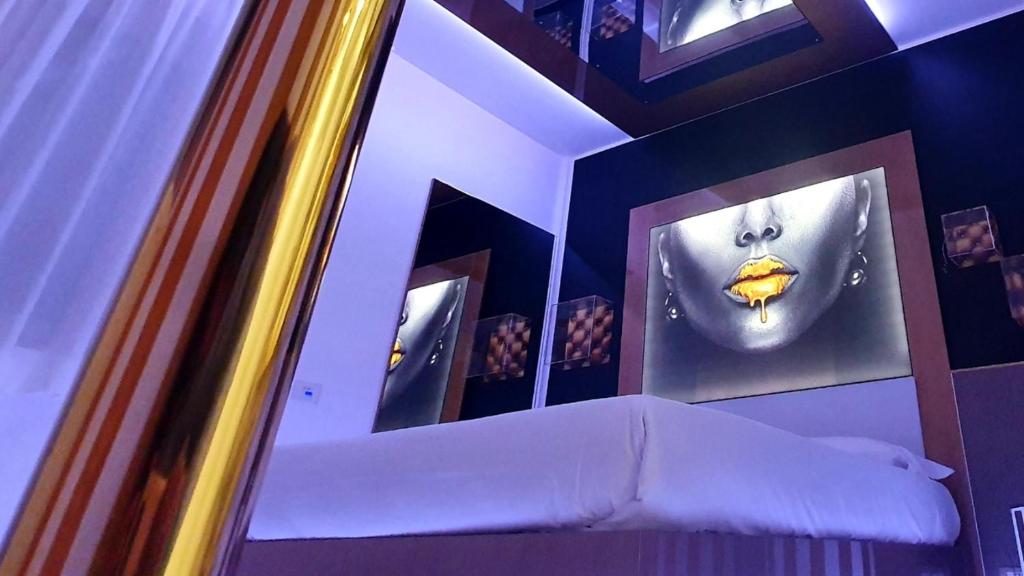 奇尼塞洛巴尔萨莫C rooms - Love Motel Monza的一间设有一面镜子的墙壁和一张床的客房