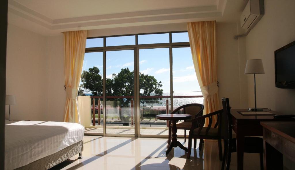 努库阿洛法翡翠酒店及餐厅的一间卧室设有一张床和一个大窗户