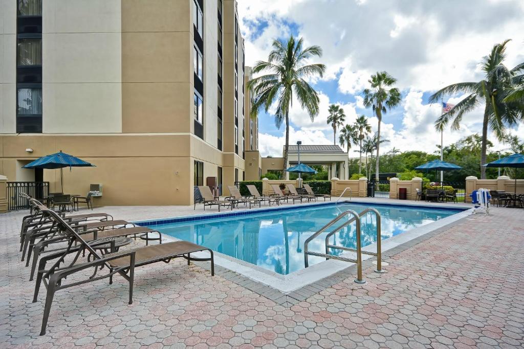 迈阿密迈阿密机场西/多拉尔凯悦酒店的游泳池,带椅子和遮阳伞