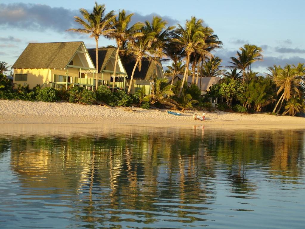 拉罗汤加白沙滩别墅的棕榈树和水滩上的别墅