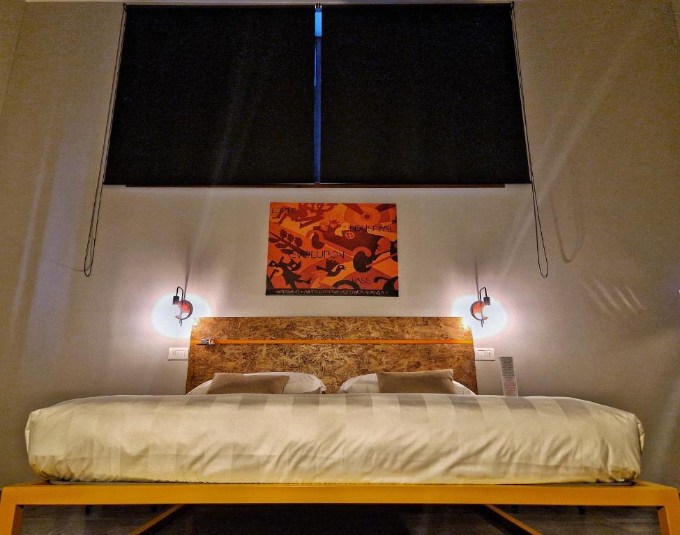 皮恩扎GARAGE47 Storica Officina Meccanica LOFT B&B iN PIENZA的一间卧室配有一张带两个灯的床