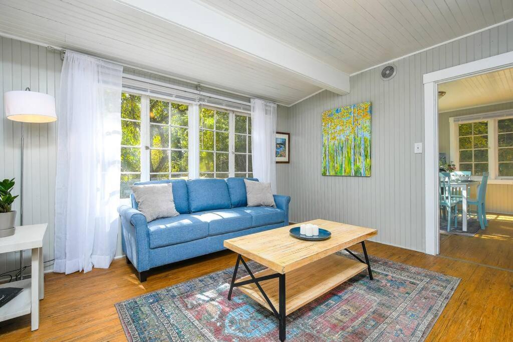 温哥华Adorable Cottage Among Trees Close To Everything的客厅配有蓝色的沙发和桌子