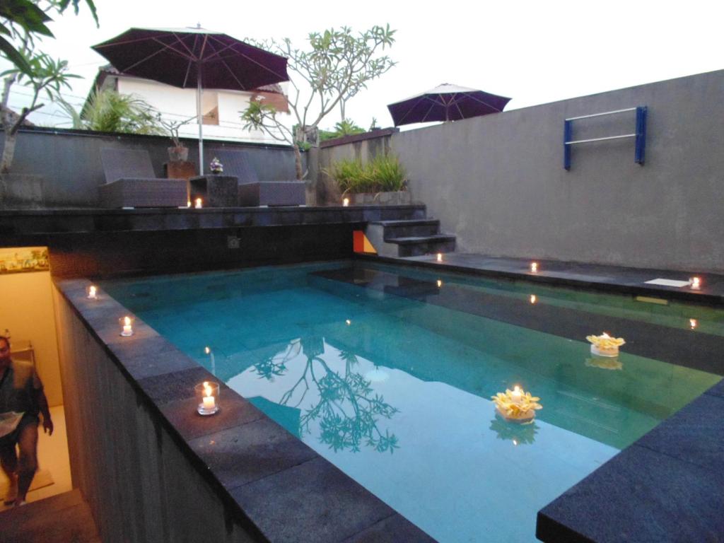 金巴兰巴厘岛大象精品别墅酒店的水中带蜡烛的游泳池