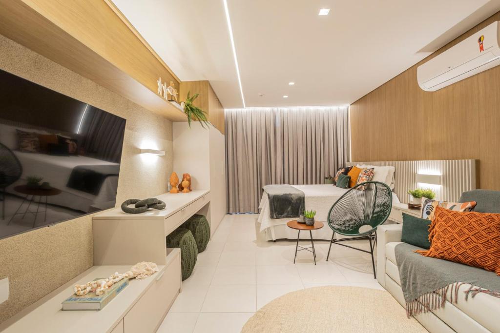 塔曼达雷FLAT 210 - ECORESORT PRAIA DOS CARNEIROS的酒店客房设有床和客厅。