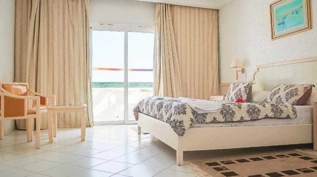 苏塞Hotel Royal Jinene Sousse的一间卧室设有一张床和一个大窗户