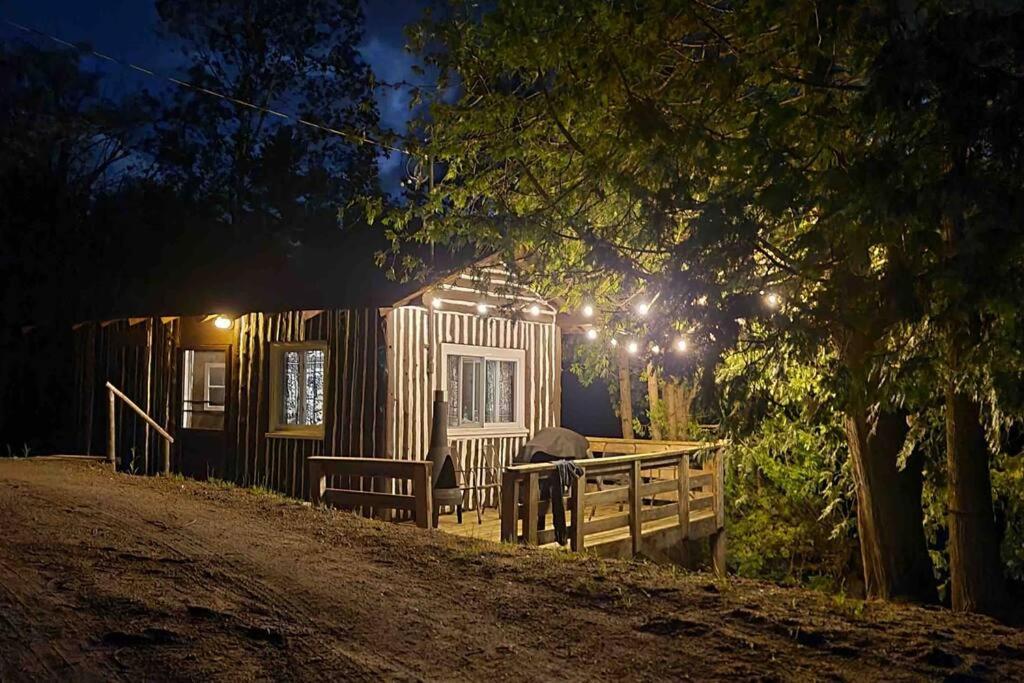 OmpahCedar Cabin - North Frontenac Lodge的小木屋前面设有长凳